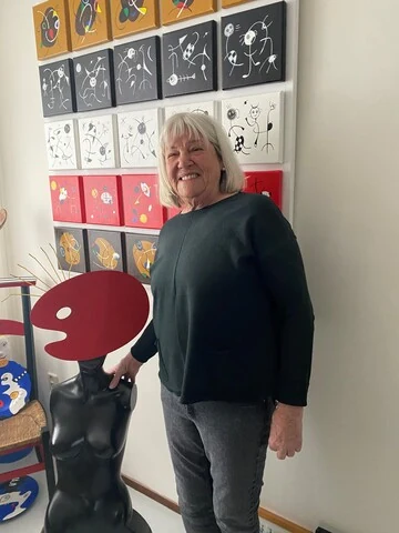Trudy Bersma in haar atelier voor een wand met eigen werk